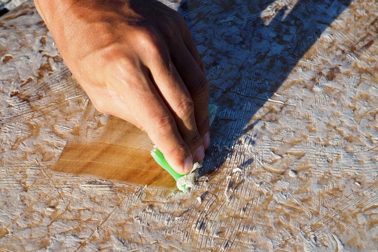 Board wax removal: use a scraper tool to collect the old wax | Photo: Shutterstock